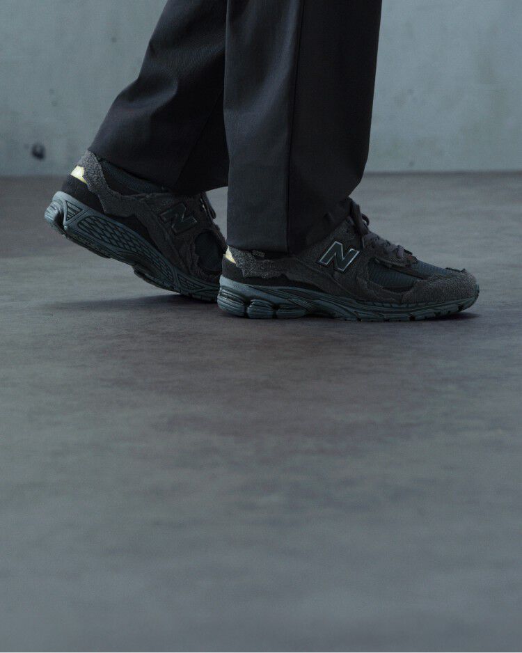 A pair of New Balance sneakers on concrete floor.